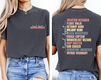 May include: A dark gray t-shirt with the text "Travel Agent" and "Vacation Designer" on the front and a list of travel-related titles on the back, including "Vacation Designer", "Flight Ninja", "Getaway Guru", "Holiday Hero", "Beach Whisperer", "Cruise Captain", "Wanderlust Wizard", "Map Master", "Sun Chaser", "Adventure Architect", and "Voyage Visionary".