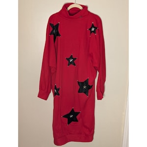 May include: A white ceramic mug with a black handle and the text "But First, Coffee" in a black, handwritten-style font. The mug is on a white surface.