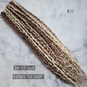 May include: A bundle of synthetic dreadlocks in shades of brown and cream. The dreadlocks are approximately 20-23 inches long. The product is labeled with the number "#71".