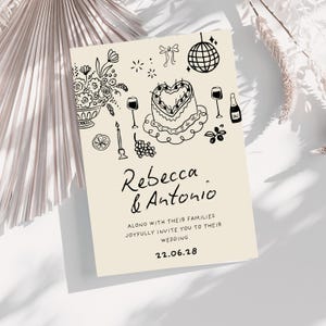 K&ouml;nnte beinhalten: Eine cremefarbene Hochzeitseinladungskarte mit schwarzen Strichzeichnungen eines herzf&ouml;rmigen Kuchens, einer Discokugel, Blumen, Weingl&auml;sern und einer Flasche. Der Text lautet Rebecca & Antonio along with their families joyfully invite you to their wedding 22.06.28.