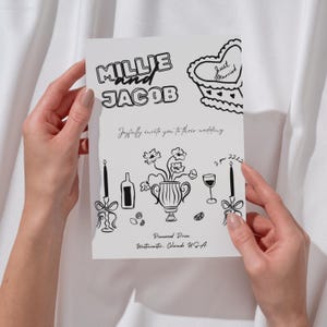 May include: A black and white wedding invitation with the names Millie and Jacob in a bold font. The invitation includes a floral illustration with a vase, candles, and a glass of wine. The text reads "Joyfully invite you to their wedding" and includes the date, time, and location.