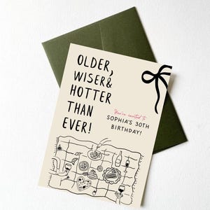 May include: A beige card with black text that reads "Older, Wiser & Hotter Than Ever!" and "You're invited to Sophia's 30th Birthday!"  The card features a black and white illustration of a picnic blanket with food and drinks.