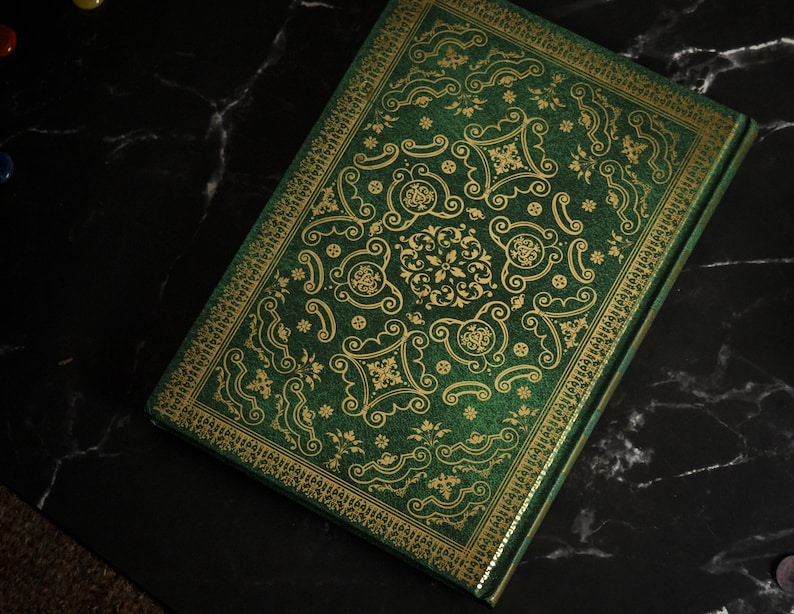Op de afbeelding: Een groen dagboek met een gouden reli&euml;fpatroon. De omslag heeft een herhalend patroon van sierlijke swirls en bloemmotieven.