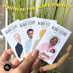 May include: Four scratch-off cards are held in a hand, each with the text "WHO HAS THE BABY DADDY?" and "SCRATCH TO REVEAL". The cards feature celebrity images. The cards are white with black text and a gold scratch-off area.