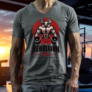 May include: Gray V-neck t-shirt featuring a muscular bull graphic with the text "REBELLION BULL FITNESS CENTER" in red and black. The bull is set against a red circular background. The shirt is made of a soft material.