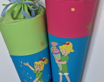 May include: Two cone-shaped fabric school cones, one with a lime green top and one with a pink top, both featuring blue lower sections with illustrations of a cartoon character. The pink cone is tied with a light pink ribbon, and the green cone with a blue ribbon. A logo with the text "Kleine Knöpfe Knopf-käfer" is visible.