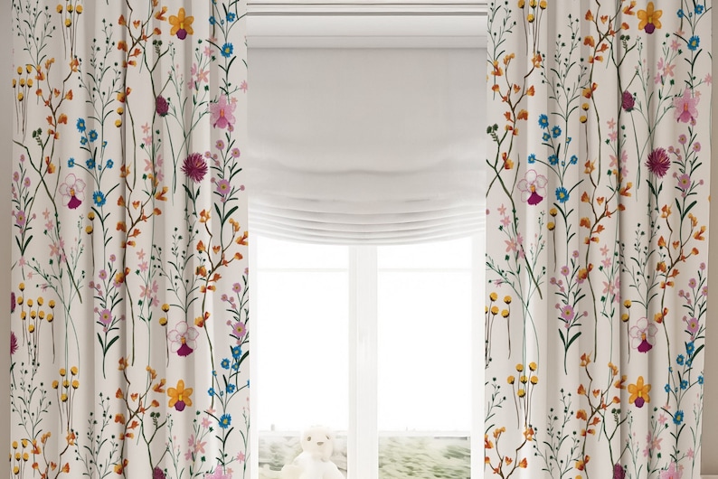 May include: Two off-white curtains featuring a repeating botanical print of wildflowers in shades of yellow, blue, pink, and magenta. The fabric displays thin green stems and various small floral blooms arranged in a vertical, scattered pattern.