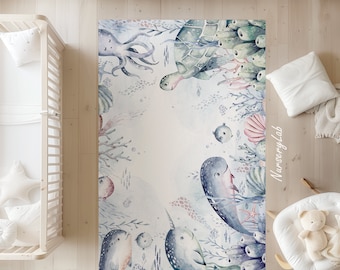 May include: A watercolor-style nursery rug featuring a whimsical underwater scene with a narwhal, octopus, turtle, and coral. The rug has a light blue background with pink, purple, and green accents.
