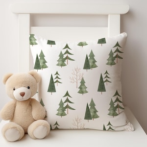May include: A white cushion with a green watercolour forest print. The cushion features a repeating pattern of stylised pine trees with brown branches.
