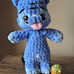 Tigre azul de pie sobre sus patas traseras con una maceta.