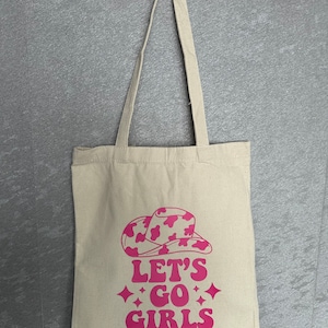 Auf geht's Mädels | Getragene rote Illustration des Texts Let's go girls op een tas van katoen