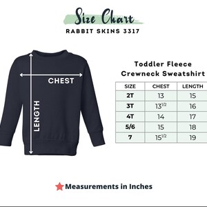 May include: Navy blue toddler fleece crewneck sweatshirt with size chart. The chart shows chest and length measurements in inches for sizes 2T to 7. The text "Size Chart" and "Rabbit Skins 3317" are at the top.