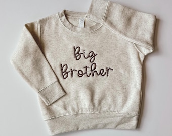 May include: A beige sweatshirt with the words "Big Brother" embroidered in brown on the front.