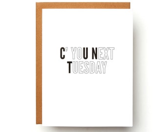 May include: A white card with black text that reads "C' YOU NEXT TUESDAY". The card has a brown envelope.
