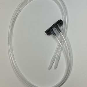 May include: Two clear plastic tubes with black connectors and three white tips. The tubes are connected to a black plastic connector with three outlets.