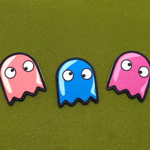 Op de afbeelding: Een set van drie keramische mokken met een gespikkelde, matte afwerking. De mokken zijn in crème, lichtgrijs en donkergrijs. Elke mok heeft een eenvoudig, minimalistisch ontwerp.