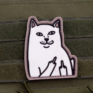 May include: A white cat patch with a gray outline, giving the middle finger with both hands. The patch is affixed to a green tactical vest with hook and loop fasteners.