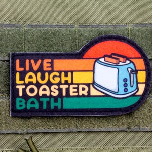 May include: A colourful patch with a retro design featuring a toaster and the text "Live Laugh Toaster Bath".