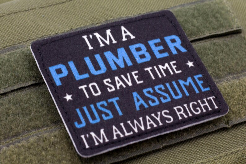 K&ouml;nnte beinhalten: Ein marineblauer Aufn&auml;her mit wei&szlig;em und blauem Text, der lautet: "I'M A PLUMBER TO SAVE TIME JUST ASSUME I'M ALWAYS RIGHT." Der quadratische Aufn&auml;her hat einen schwarzen Rand. Er ist vor einem gr&uuml;nen Hintergrund platziert.