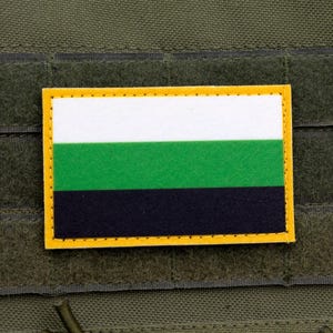 May include: A rectangular patch with a yellow border, featuring horizontal stripes of white, green, and black. The patch is affixed to a green fabric background, likely a tactical vest or similar gear.