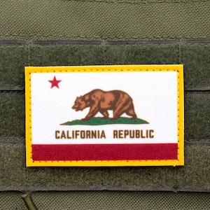 Könnte beinhalten: Ein gelber, roter und weißer Patch mit einem braunen Bären und dem Text "CALIFORNIA REPUBLIC".