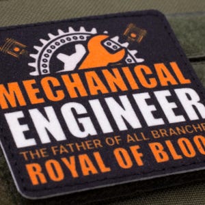 Pu&ograve; includere: Toppa quadrata con le parole "MECHANICAL ENGINEER" in bianco e arancione, e il testo "THE FATHER OF ALL BRANCHES ROYAL OF BLOOD". La toppa presenta una chiave inglese, un ingranaggio e un pistone.