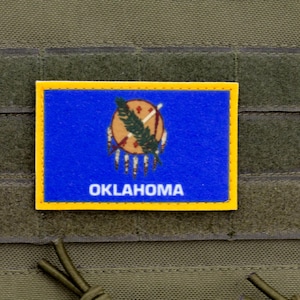 May include: A blue and yellow patch with the state seal of Oklahoma and the word "OKLAHOMA" in white lettering.