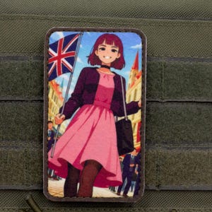 May include: Rectangular patch featuring an anime-style illustration of a person holding a Union Jack flag. The person wears a pink dress, black jacket, and carries a black bag. The background depicts a street scene with buildings.