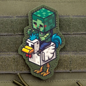 Könnte beinhalten: Ein grünes und blaues Minecraft-Patch mit einem Zombie, der auf einem weißen Huhn reitet. Der Aufnäher hat einen grünen Rand und ist vor einem grünen Hintergrund platziert. Das Huhn hat einen gelben Schnabel und Füße sowie einen blauen Schwanz.