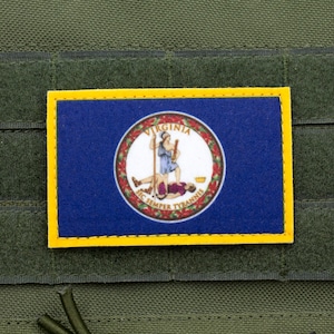 Könnte beinhalten: Ein blauer und gelber Patch mit dem Staatssiegel von Virginia. Das Siegel zeigt eine Frau, die auf einem Mann steht, mit den Worten "Sic Semper Tyrannis" drumherum.