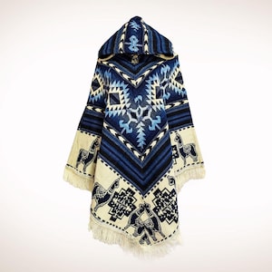 Könnte beinhalten: Ein Kapuzenponcho mit einem geometrischen Muster in Blau-, Schwarz- und Cremetönen. Der Poncho hat einen Fransenbesatz und Lama-Designs am unteren Teil. Das Design umfasst eine Vielzahl von Formen und Mustern.