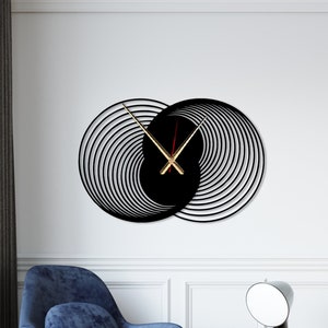 May include: A black and gold wall clock with a unique spiral design. The clock hands are gold and the clock face is black.