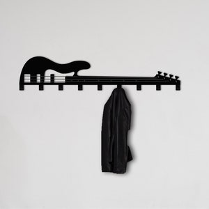 May include: Black metal wall-mounted coat rack shaped like a bass guitar with six hooks. A black jacket is hanging on one of the hooks.
