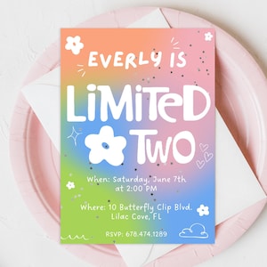 May include: A colorful birthday invitation with the text "Everly is Limited Two" on a gradient background of orange, pink, blue, and green. The invitation is on a pink plate with a white envelope.