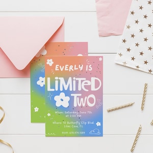 May include: A birthday party invitation with a gradient background in pink, orange, green, and blue. The invitation reads "Everly is Limited Two" with floral and star accents. Includes a pink envelope, gold ribbon, candles, and a star-patterned bag.