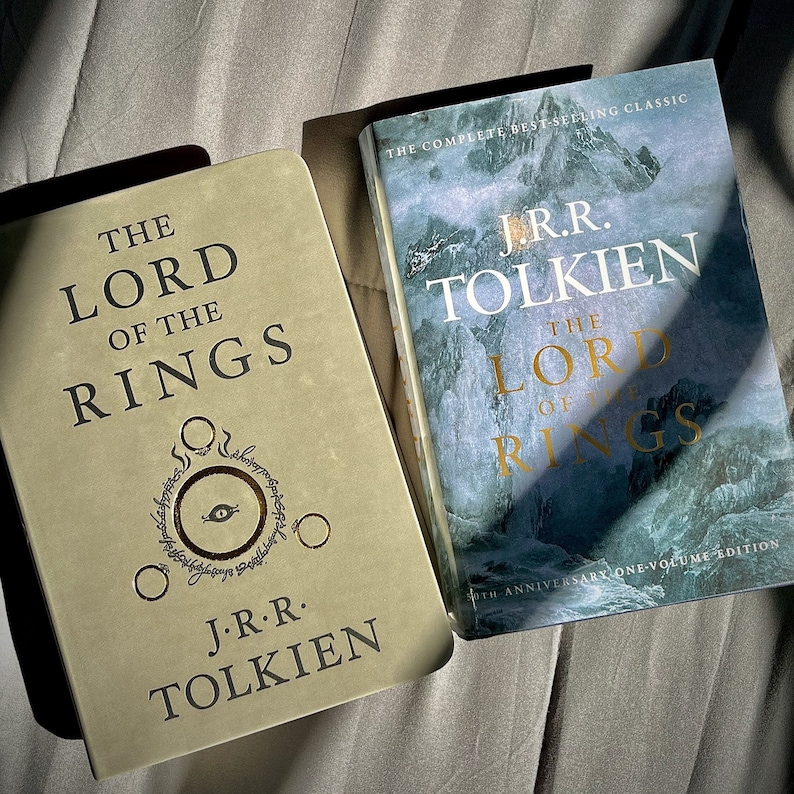 Pu&ograve; includere: Due copie de Il Signore degli Anelli di J.R.R. Tolkien. Un libro ha una copertina color sabbia con un simbolo dell'occhio in lamina d'oro e testo nero. L'altro &egrave; un'edizione del 50&deg; anniversario con copertina blu di montagna e scritte dorate.
