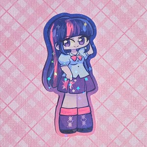 May include: A sticker featuring a cartoon character with long, dark purple hair with pink highlights. The character wears a light blue shirt, a purple skirt with star accents, and purple boots. The sticker has a holographic effect and is set against a pink background.