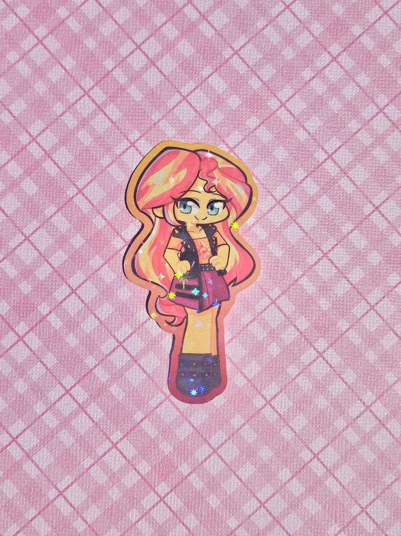 May include: A colorful sticker featuring a cartoon character with pink and yellow hair, blue eyes, and a black vest. The character is wearing a pink skirt and black boots. The background is a pink plaid pattern.