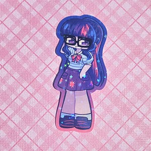 May include: A sticker featuring a cartoon character with dark blue hair, glasses, and a purple skirt adorned with stars. The character wears a white shirt with a blue striped top and a pink bow. The sticker is set against a pink checkered background.