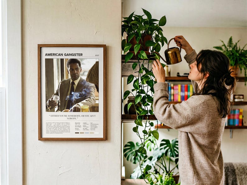American Gangster poster, Light edition, framed and on the wall beside someone watering the plants
