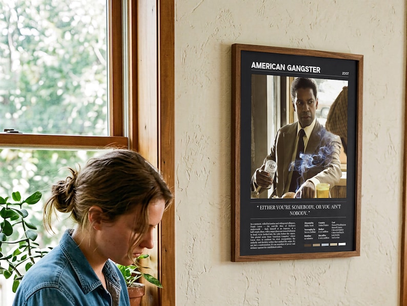 American Gangster poster, Dark edition, framed and on the wall beside someone repotting a plant