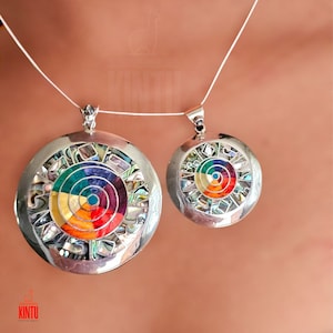 Puede incluir: Dos collares de plata con colgantes redondos que presentan un dise&ntilde;o circular colorido hecho de n&aacute;car incrustado. El colgante m&aacute;s grande tiene un di&aacute;metro de aproximadamente 5 cm.