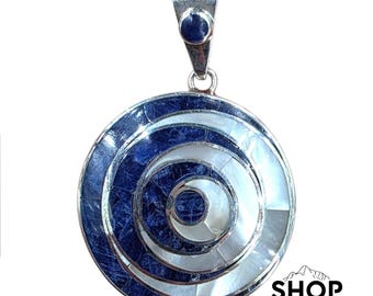 Può includere: Ciondolo circolare con un'ansa argentata e un design concentrico blu e bianco. Il ciondolo presenta un cerchio bianco centrale circondato da fasce alternate di pietra blu e conchiglia bianca. Il ciondolo è di Shop Peru.