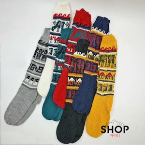 May include: Six pairs of colourful knitted socks with geometric patterns. The socks are made of wool and have a traditional Peruvian design. The socks are all different colours, including red, blue, yellow, green, and white.