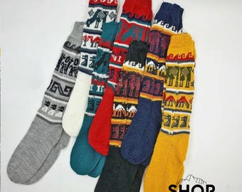 May include: Six pairs of colourful knitted socks with geometric patterns. The socks are made of wool and have a traditional Peruvian design. The socks are all different colours, including red, blue, yellow, green, and white.