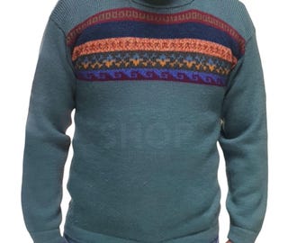 Può includere: Un maglione girocollo color verde acqua con un motivo a giogo. Il giogo presenta fasce di disegni geometrici rossi, blu navy, arancioni e blu. Il maglione ha maniche lunghe e un collo a coste.