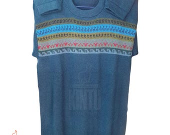 Può includere: Maglione color verde acqua con girocollo e maniche corte. La parte superiore del petto presenta una fascia a fantasia con strisce orizzontali blu, gialle, rosse e grigie. Il maglione ha un logo nell'angolo in basso a sinistra che dice "KINTU".