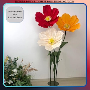 May include: Three large artificial flowers: one red, one orange, and one cream-colored, each with a yellow center. The flowers are 24 inches in diameter and have 5.3ft tall stems. The text on the image says "24-inch Flower with 5.3ft Tall Stem".