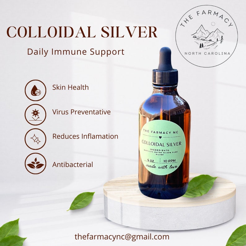 Puede incluir: Una botella de vidrio marr&oacute;n con un gotero, etiquetada "The Farmacy NC Colloidal Silver 4 oz 10 PPM made with love". La botella est&aacute; sentada sobre una superficie de madera con hojas verdes. La etiqueta tambi&eacute;n incluye el texto "Ingredientes: Agua purificada y 10 PPM de plata pura".