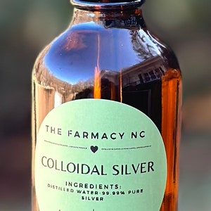 Puede incluir: Una botella de 118 ml de plata coloidal con un gotero. La etiqueta es verde y dice "The Farmacy NC" y "Colloidal Silver". Los ingredientes se enumeran como "Agua destilada - 99,99% plata pura" y la concentraci&oacute;n es de 10 PPM. La etiqueta tambi&eacute;n dice "hecho con amor".